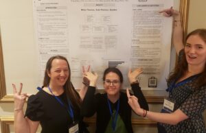 Three Powell School Students Pose in front of their research poster